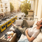 Seitenschläfer Ohrstöpsel von Berlin Ear Guard - Ohresntöpsel gegen Schnarchen zum Schlafen und gegen Lärm wie Verkehrslärm. Ein Mann sitzt auf einem Balkon in der Berliner Innenstadt ud etsannt, obwohl es extrem laut ist, weil grad die Straenbahn vorbei fährt.